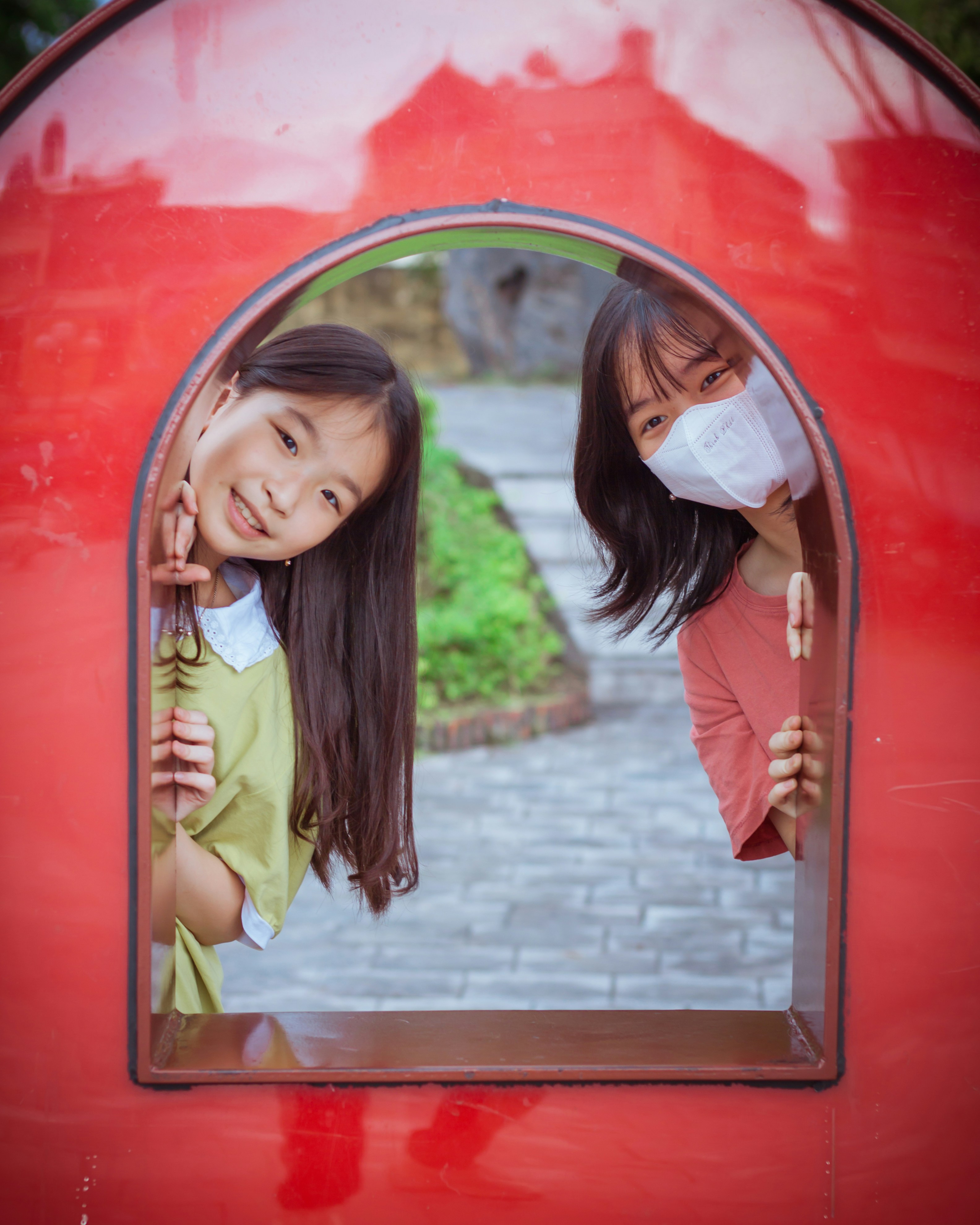 Due ragazze in piedi davanti a una struttura rossa