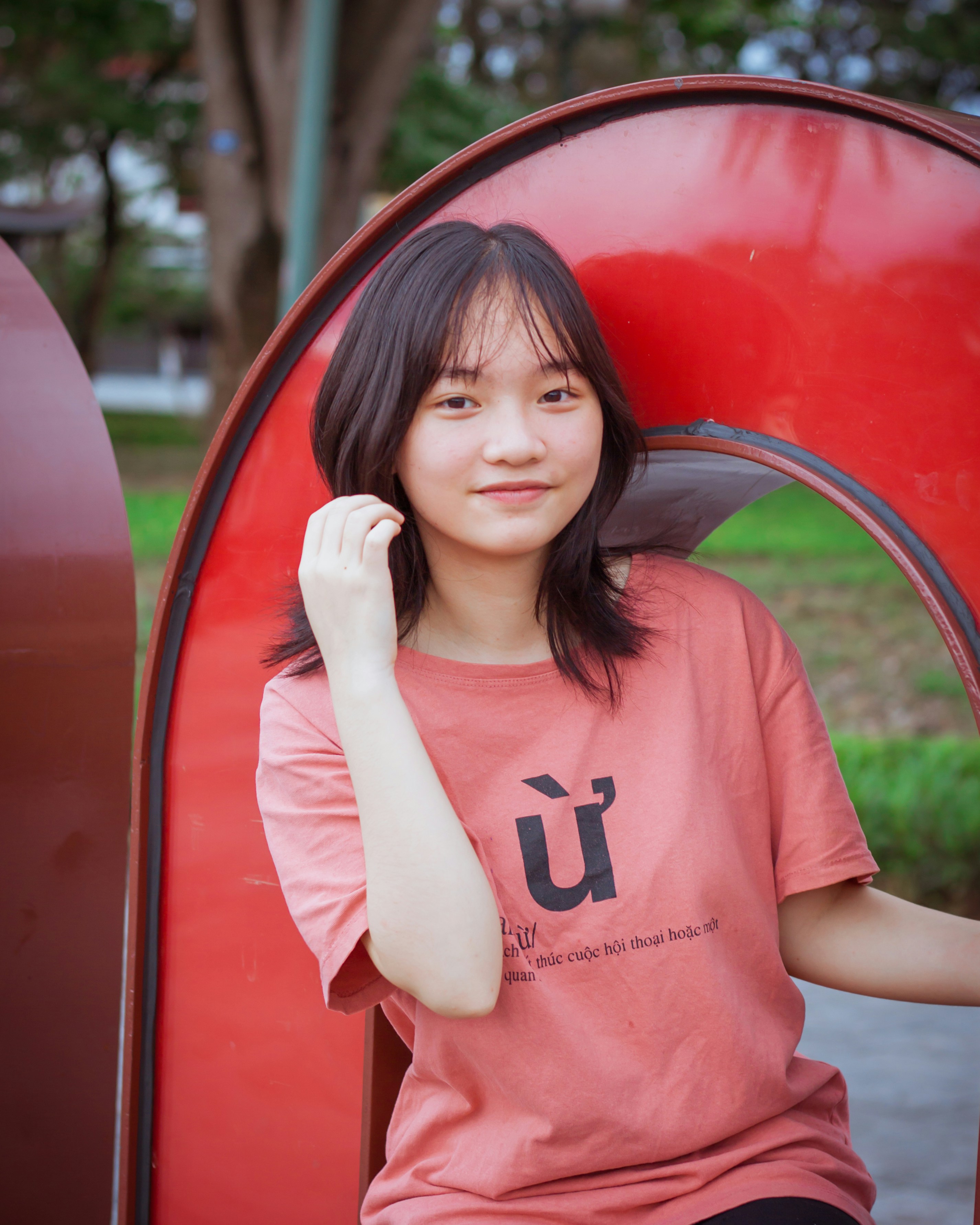 Una donna seduta su una panchina rossa in un parco