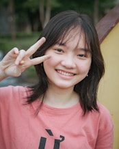 a young woman making a peace sign with her fingers