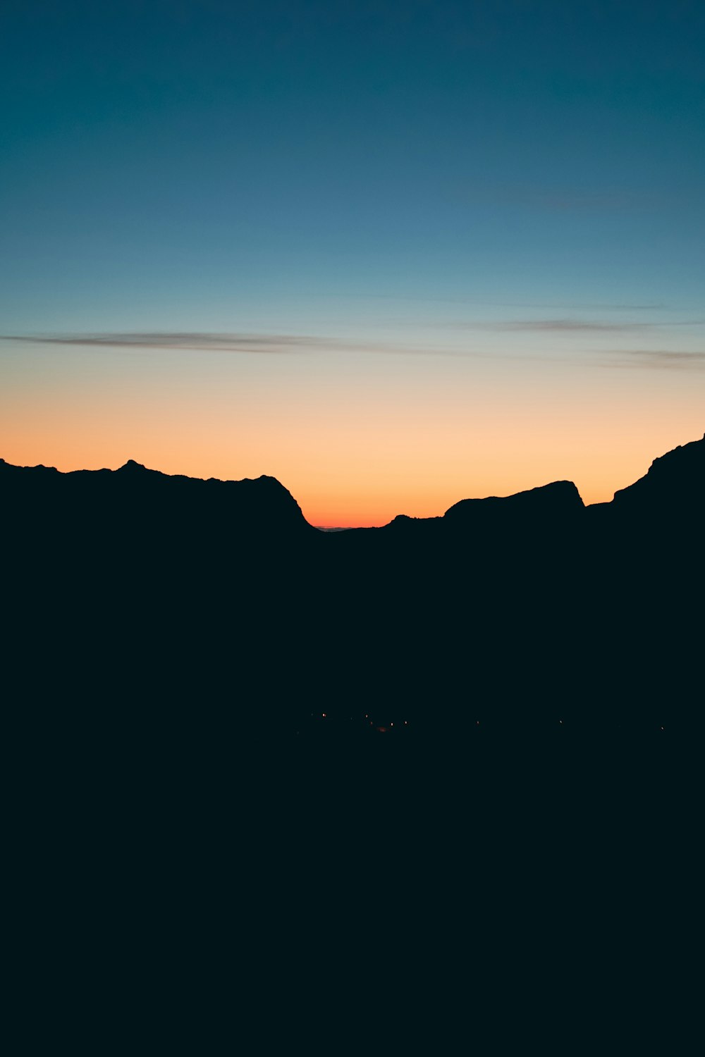 the sun is setting over a mountain range