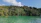 Kayakers paddling through lush green mangroves under a bright blue sky.