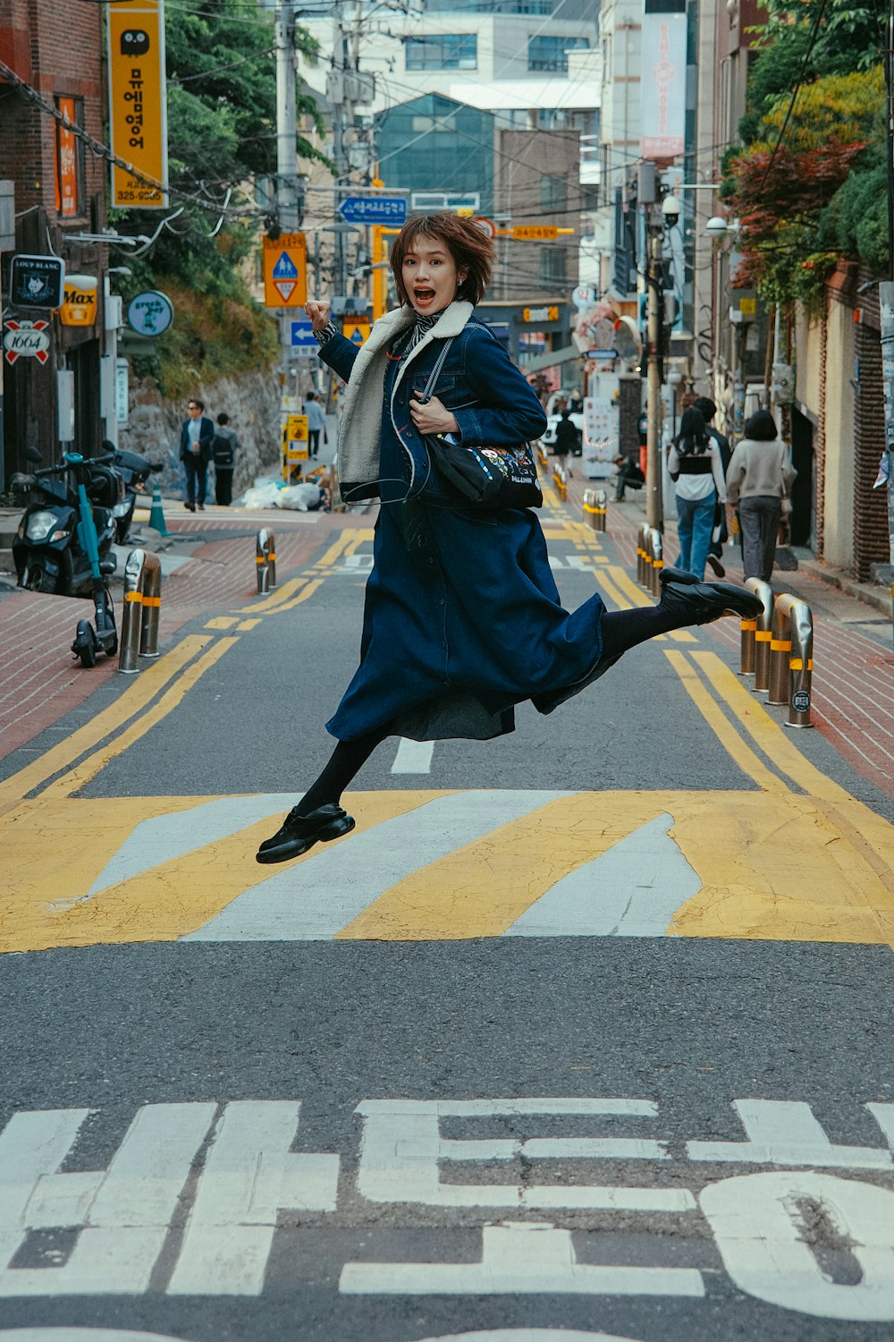 a woman jumping in the air on a city street