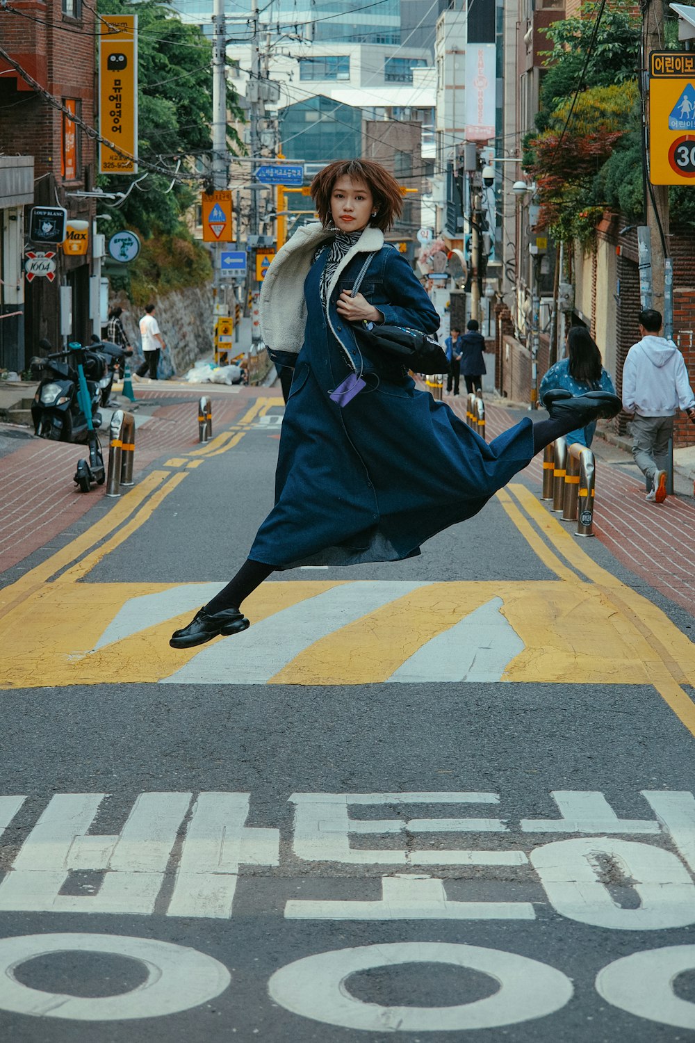 Una mujer saltando en el aire en una calle de la ciudad