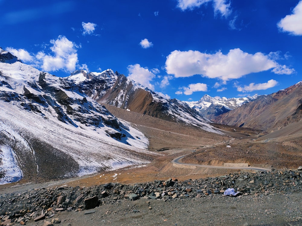 a scenic view of a mountain range with a road in the foreground