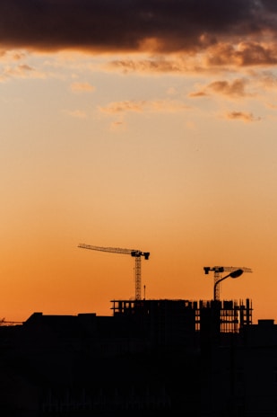 a building under construction with cranes in the background