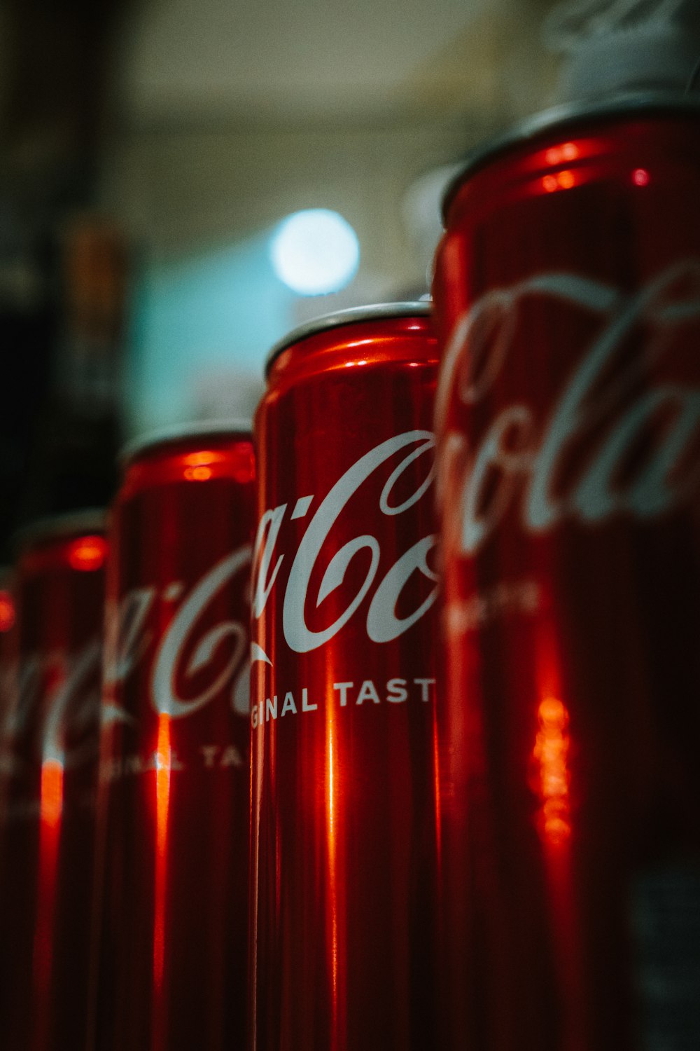 a row of red coca cola cans sitting next to each other