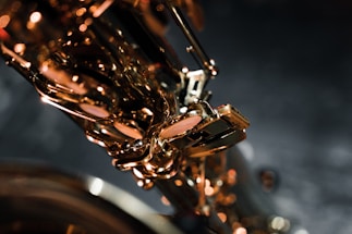 A close-up of saxophone keys shining under warm stage lights.