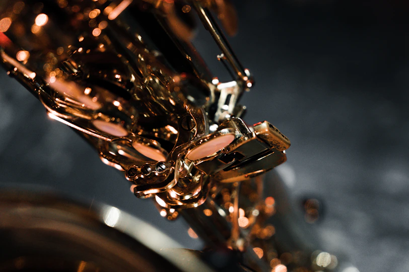 Close-up of a saxophone gleaming with reflections of stage lights during an intimate moment.