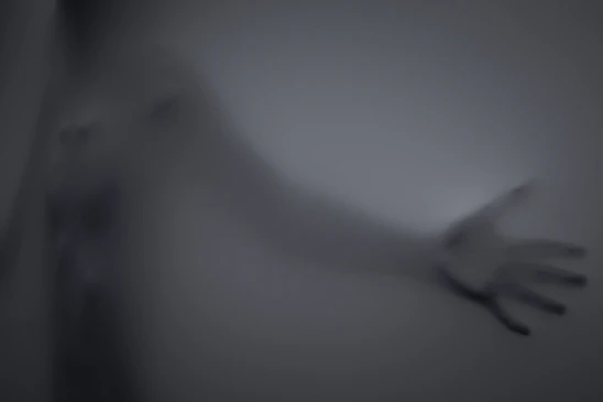 A mysterious digital ghostly figure emerging from a glowing computer screen in a dark room.