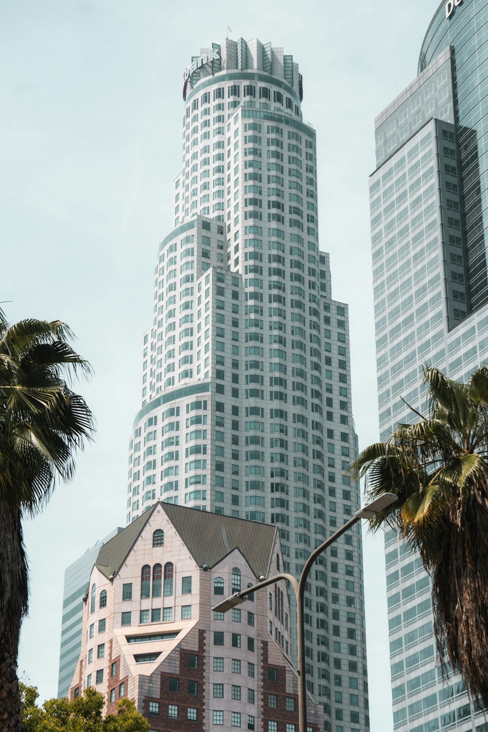 a tall white building sitting next to palm trees