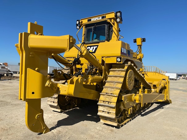 Close-up of a bulldozer blade pushing earth on a sunny day.