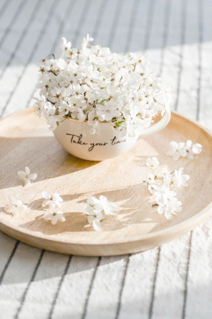 A serene moment captured with a cup of golden turmeric latte resting on a soft linen cloth beside a small vase of wildflowers.