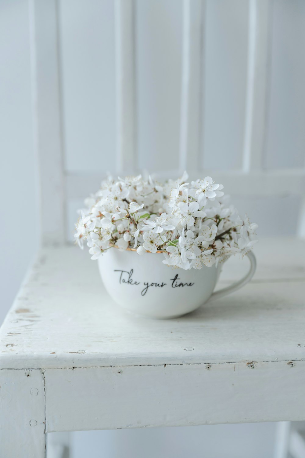 a white chair with a bowl of flowers on it