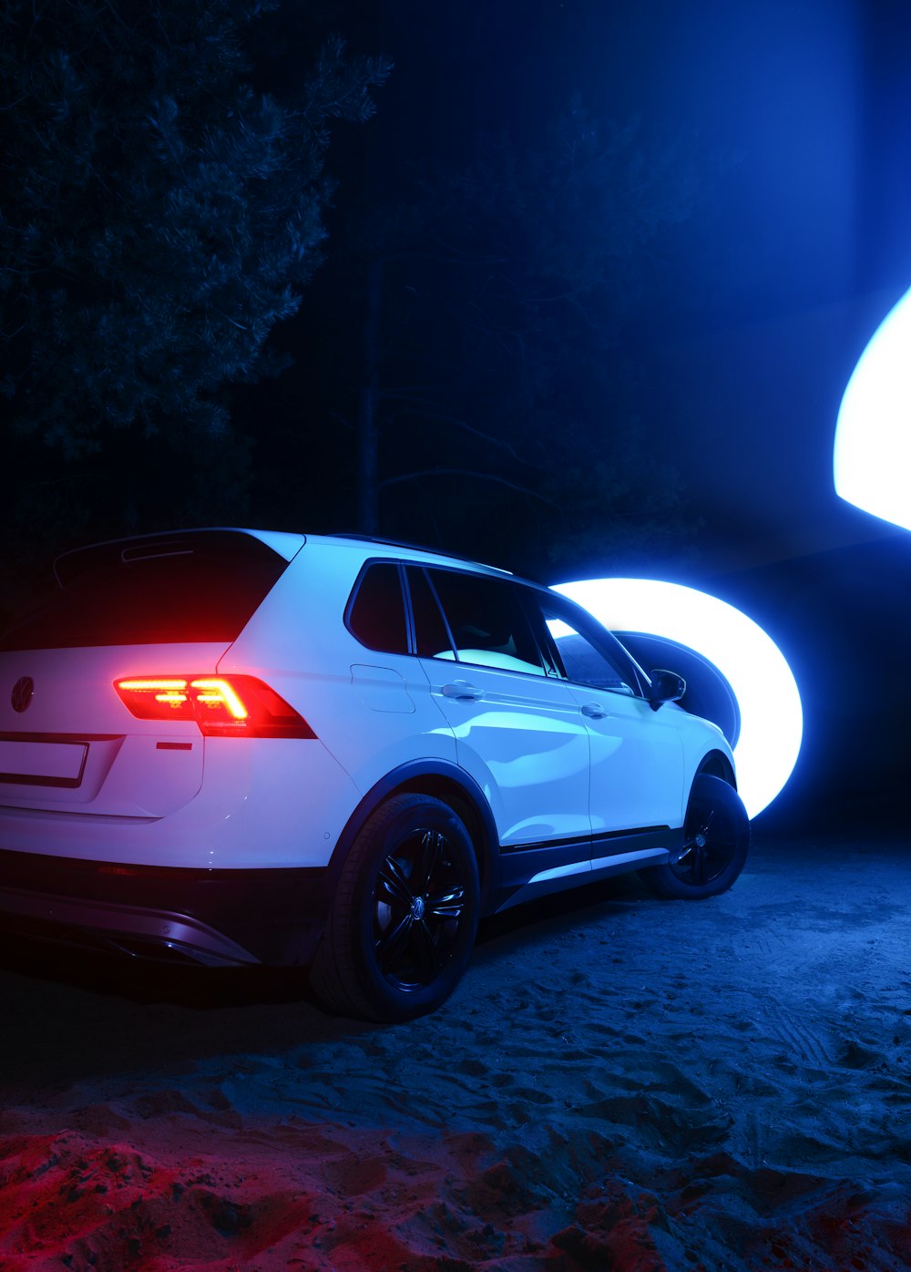 a white car parked in a parking lot at night