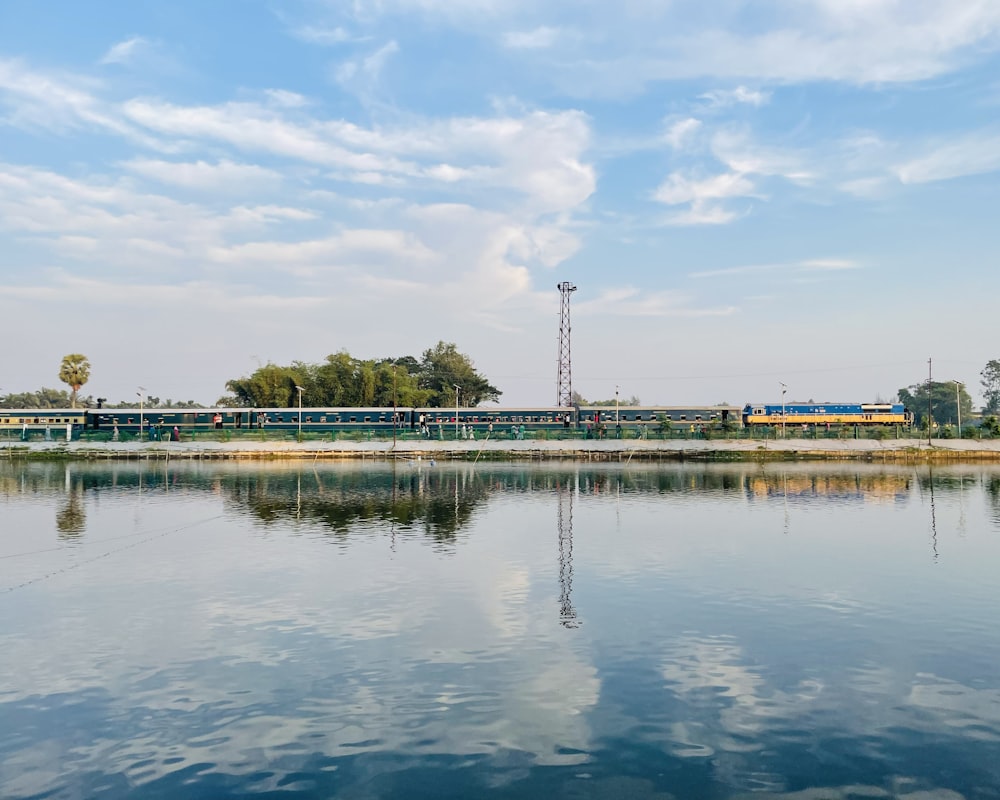 a large body of water with a train in the background