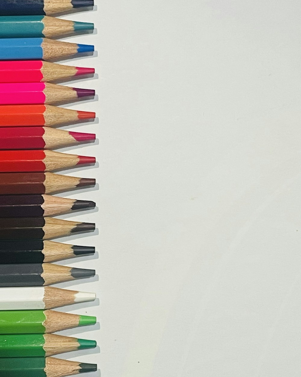 a row of colored pencils sitting on top of each other