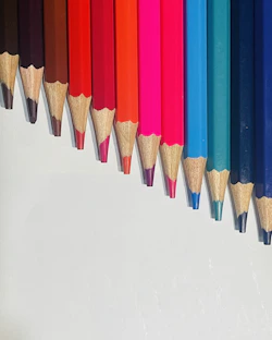 a row of colored pencils lined up in a row