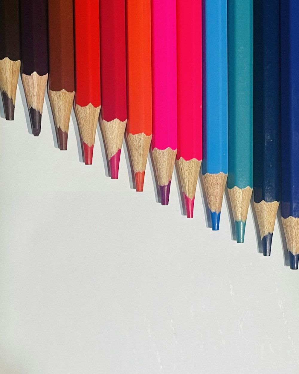a row of colored pencils lined up in a row