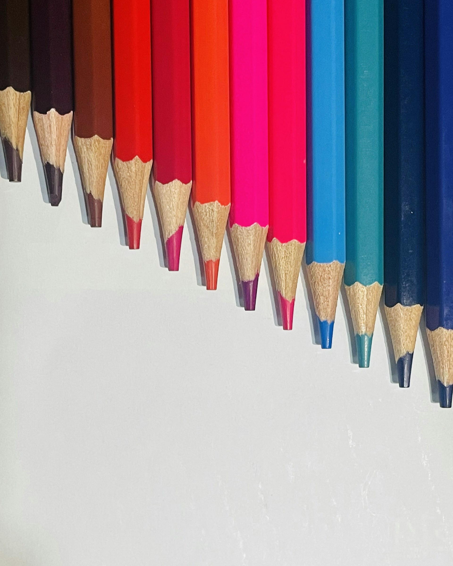 a row of colored pencils lined up in a row