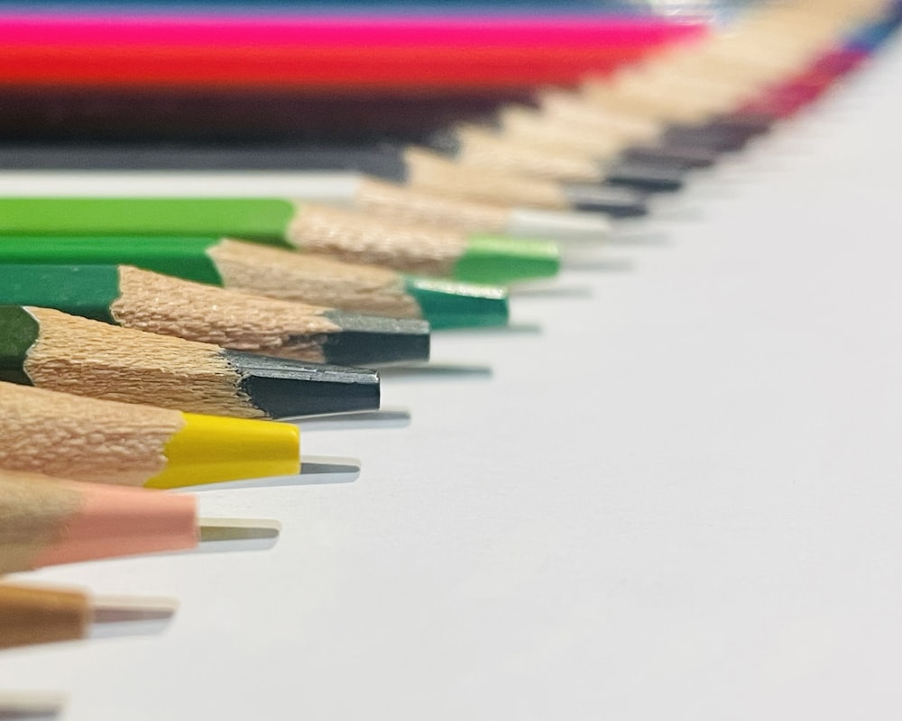 a row of colored pencils sitting next to each other