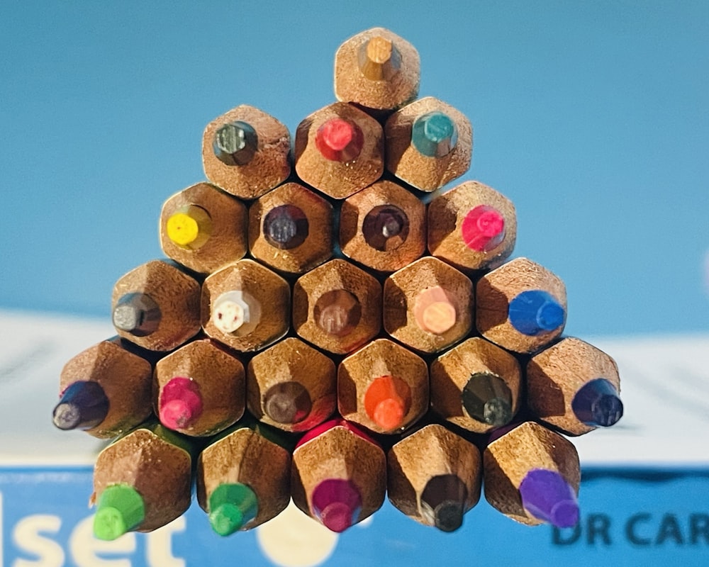 a bunch of colored pencils stacked on top of each other
