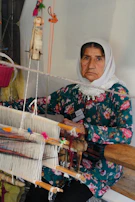 Women learning traditional handloom weaving under expert guidance.