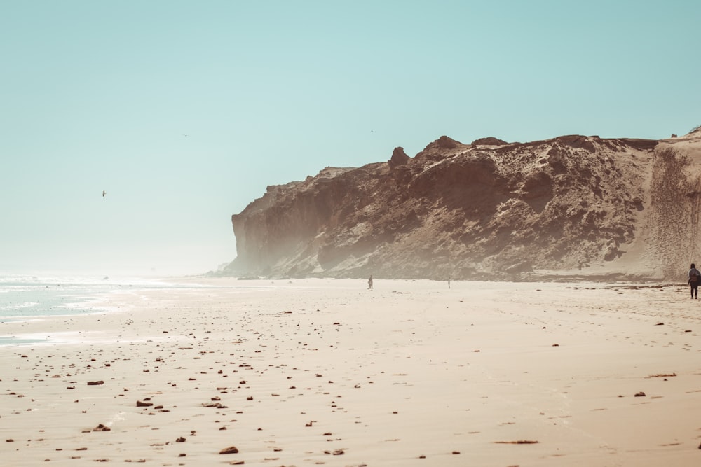 Una persona caminando en una playa junto al océano