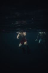 Evening swim practice with swimmers training under pool lights