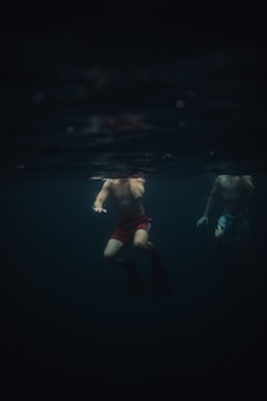 Evening swim practice with swimmers training under pool lights