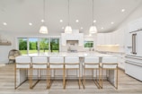 a large kitchen with a center island and white cabinets