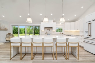 a large kitchen with a center island and white cabinets