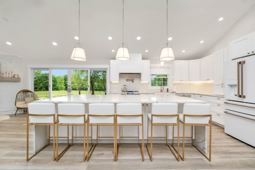 a large kitchen with a center island and white cabinets