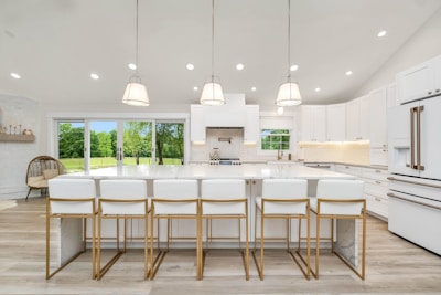 a large kitchen with a center island and white cabinets