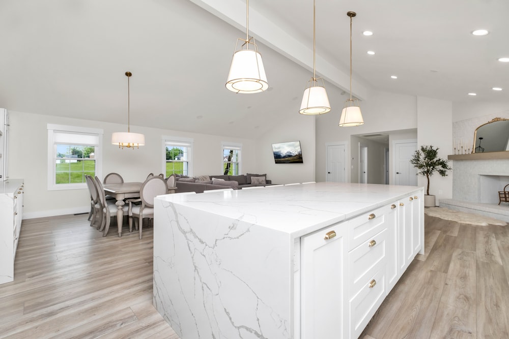 a large white kitchen with a marble island