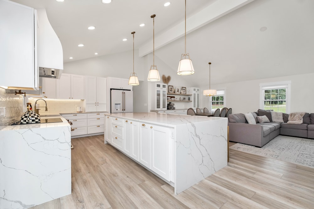 a large kitchen with a center island and marble counter tops