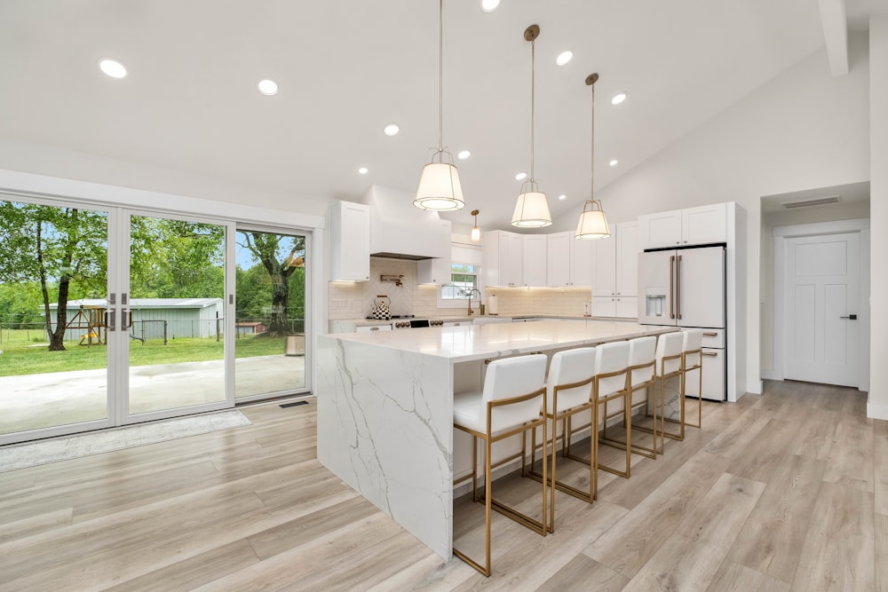 a large kitchen with a center island and marble counter tops