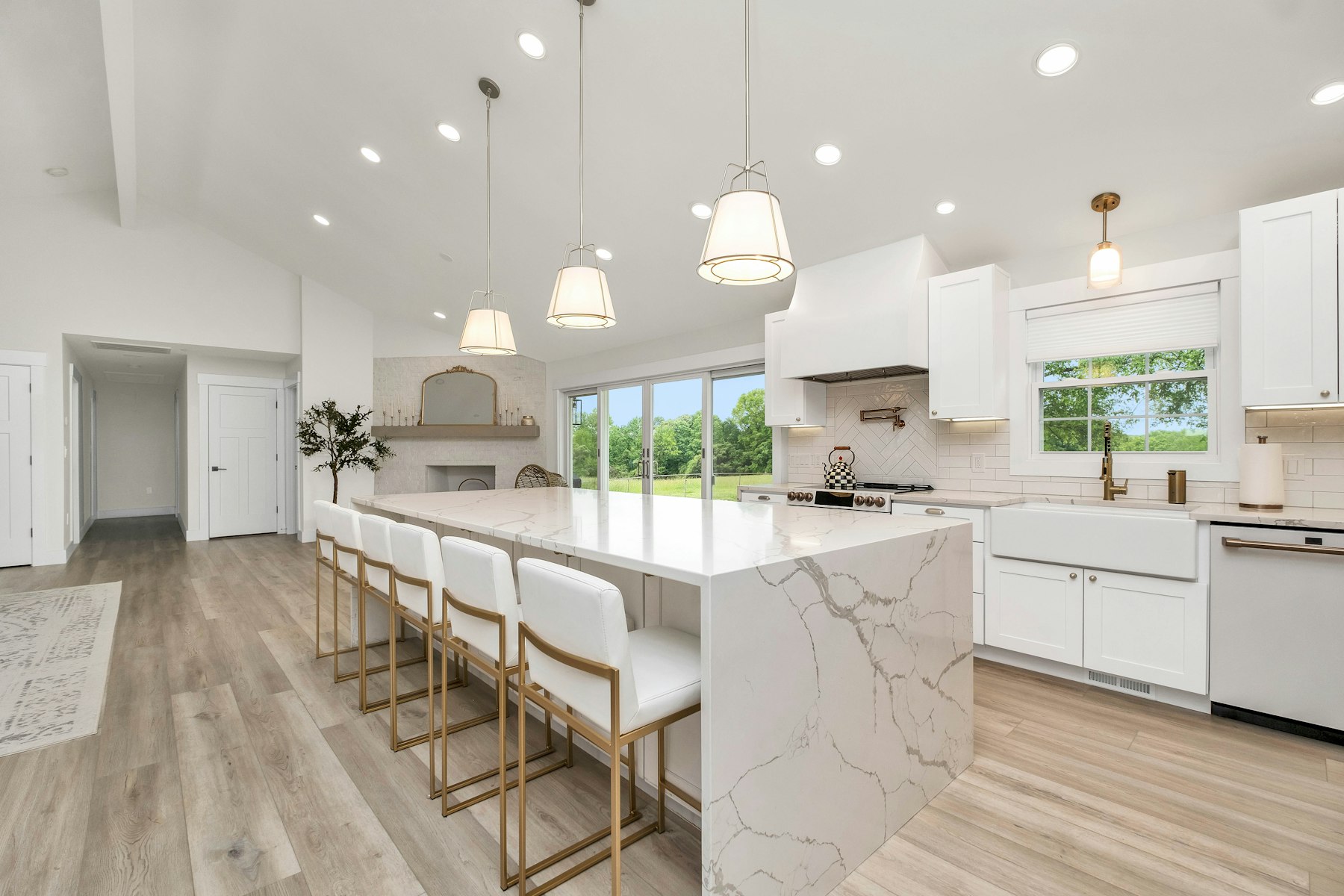 Bright kitchen with a white marble waterfall island and seating