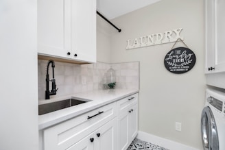 a laundry room with a sink and a washer and dryer