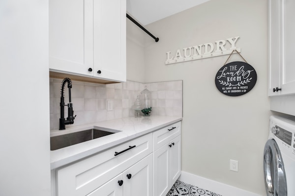 a laundry room with a sink and a washer and dryer