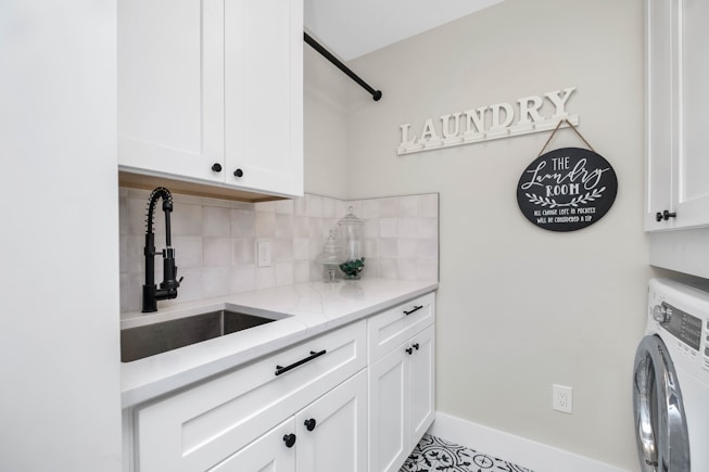 a laundry room with a sink and a washer and dryer