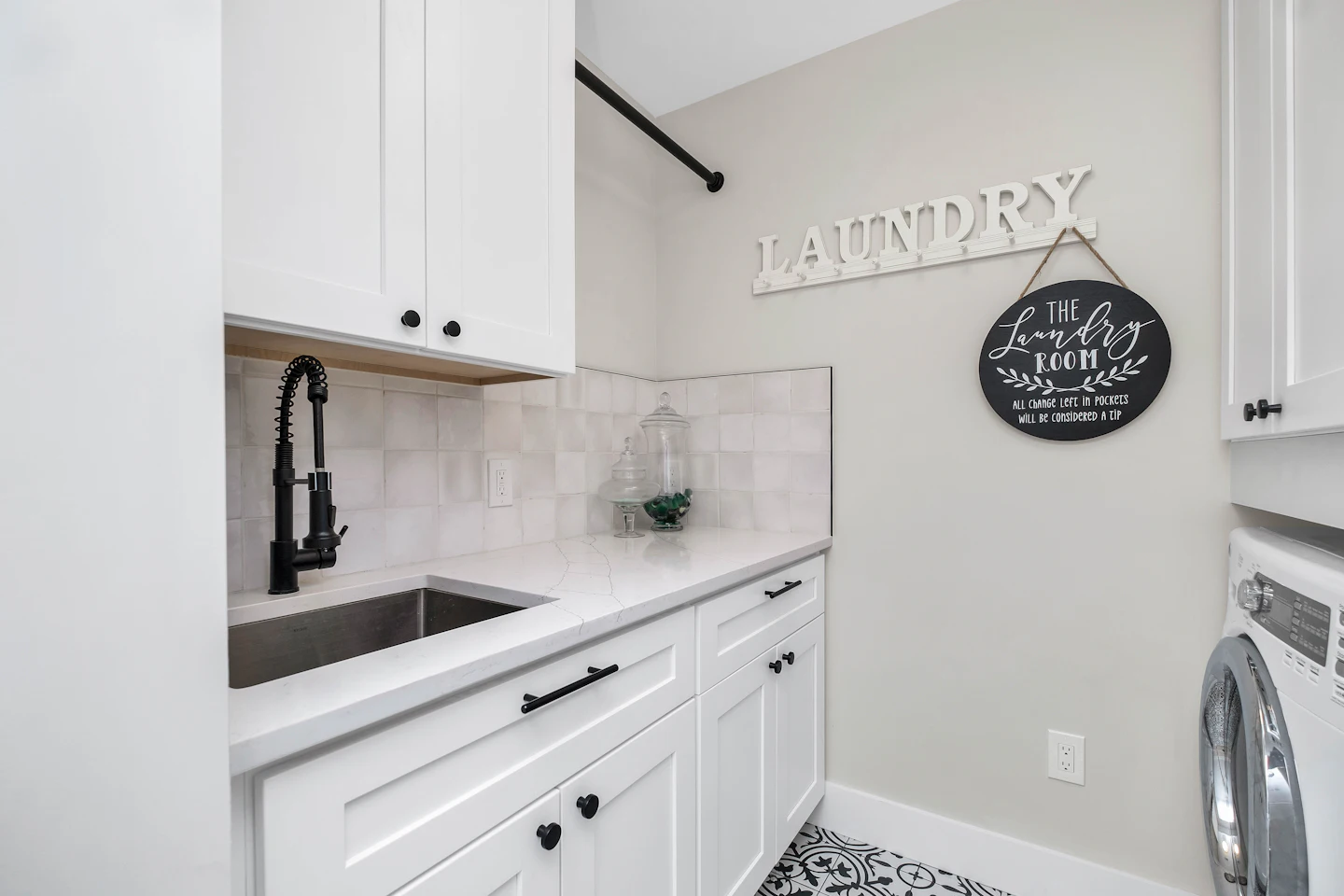 Laundry room with white cabinets, a utility sink and a washer and dryer