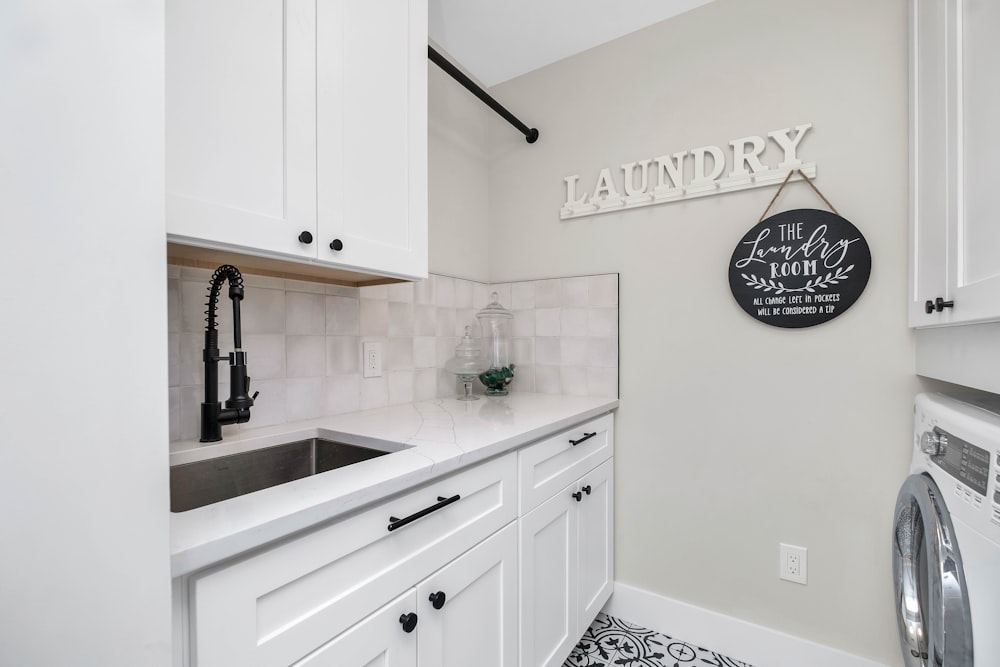 a laundry room with a sink and a washer and dryer