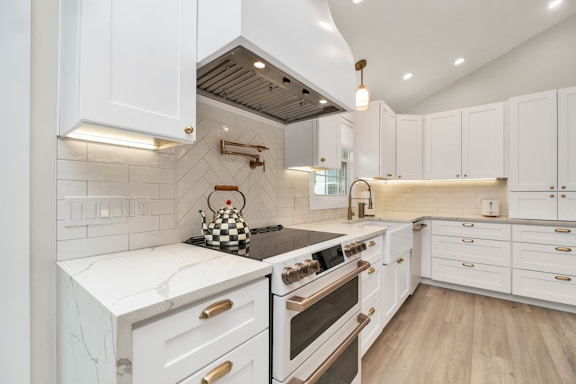 a kitchen with white cabinets and a stove top oven