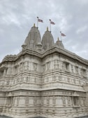a large white building with three flags on top of it