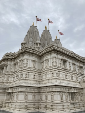 a large white building with three flags on top of it