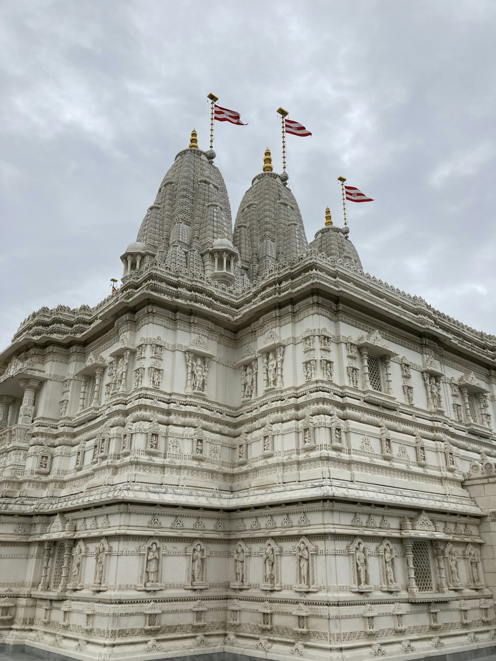 a large white building with three flags on top of it