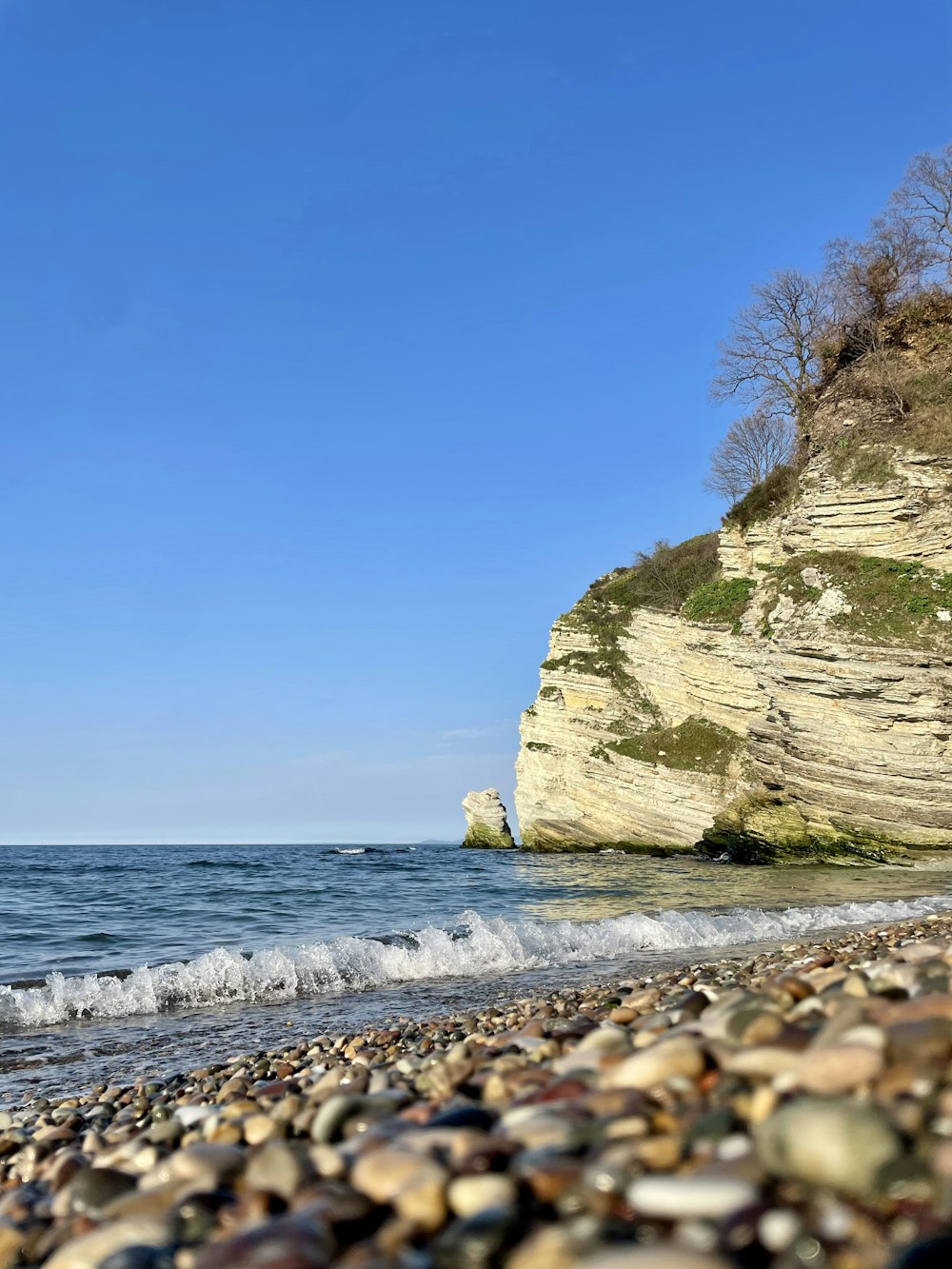 a rocky beach with a cliff in the background