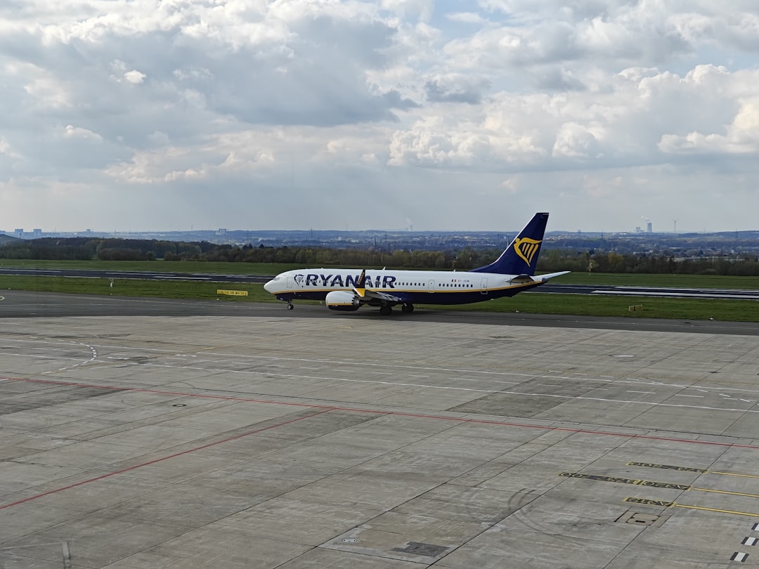 a large jetliner sitting on top of an airport tarmac, A Ryanair 737-MAX8 taxiing to a gate