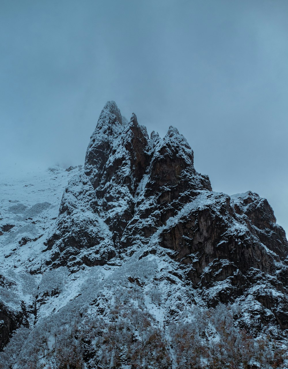 a mountain covered in snow on a cloudy day