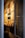 A narrow entryway filled with neatly arranged magazines and brochures on a wooden shelf. The wall features several framed posters, mostly promoting travel and lifestyle content. The ambient lighting casts a warm glow, creating a cozy atmosphere.